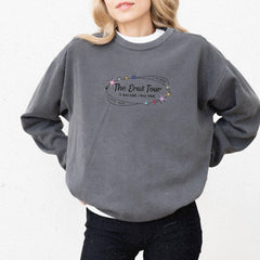 a woman wearing a grey sweatshirt with the words the great tour on it
