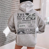 a person standing in a bathroom wearing a gray hoodie