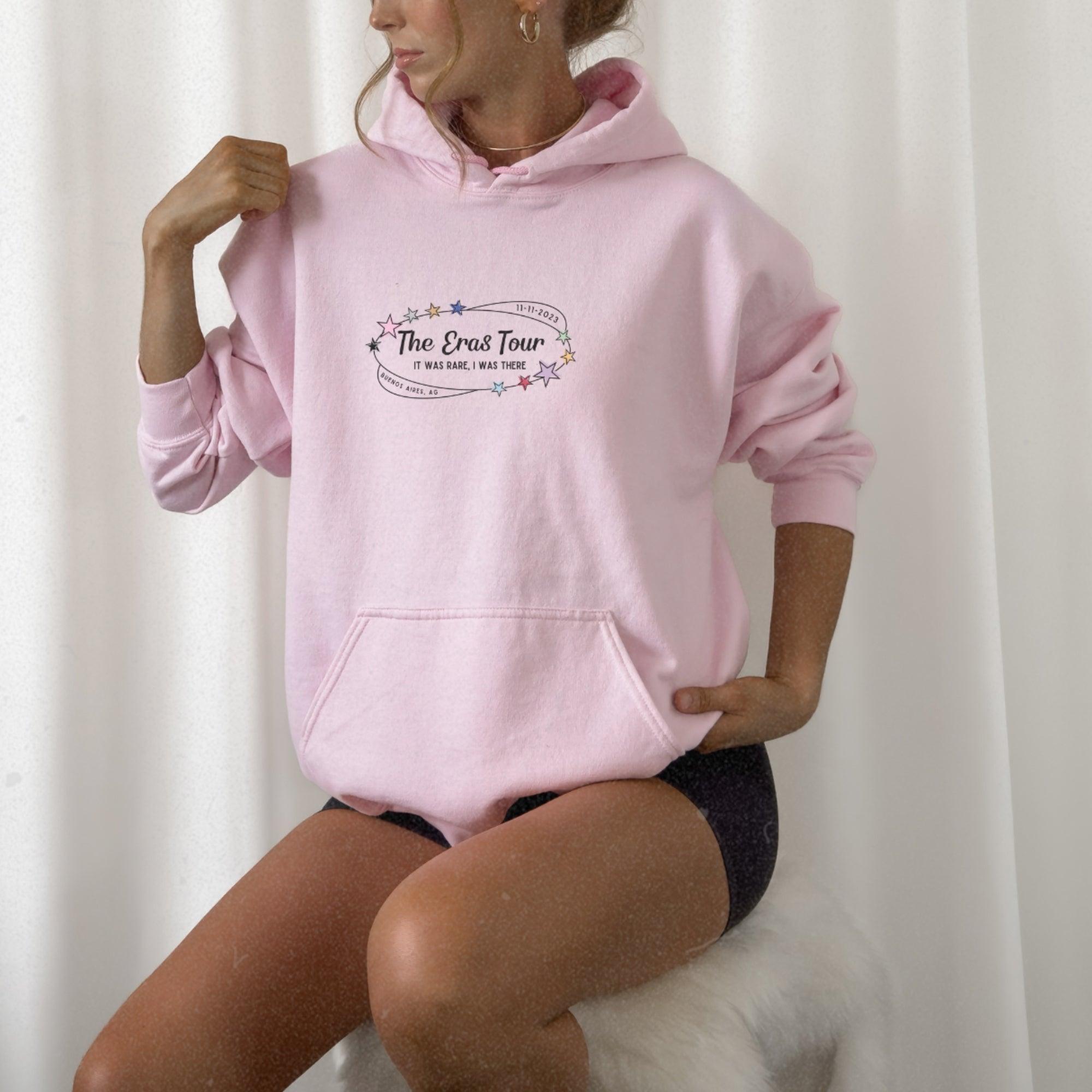a woman in a pink hoodie is posing for a picture