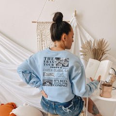 a woman sitting on a stool reading a book