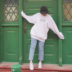 a woman leaning against a green door