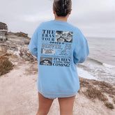 a woman standing on a beach looking at the ocean
