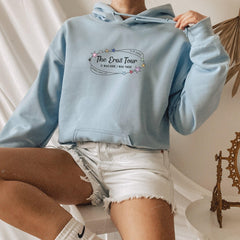 a woman sitting on a toilet wearing a blue hoodie