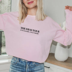 a blonde woman wearing a pink sweatshirt and jeans