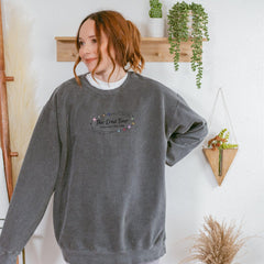 a woman standing in front of a wall with a plant
