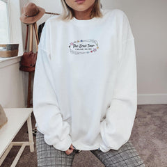 a woman wearing a white sweatshirt and plaid pants
