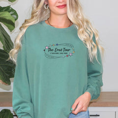 a woman wearing a green sweatshirt with the words the bros tour on it
