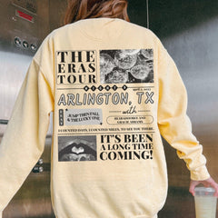 a woman in a yellow sweatshirt is holding a drink