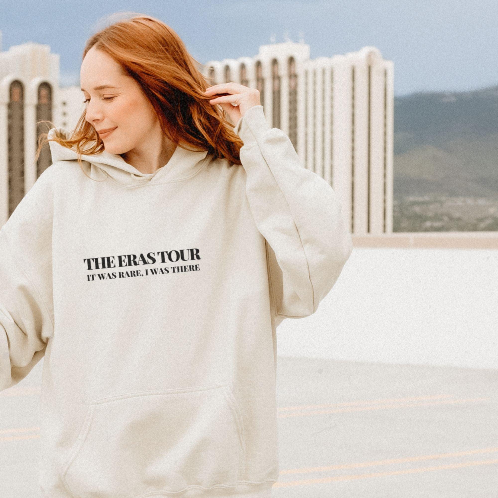 a woman with red hair wearing a white sweatshirt