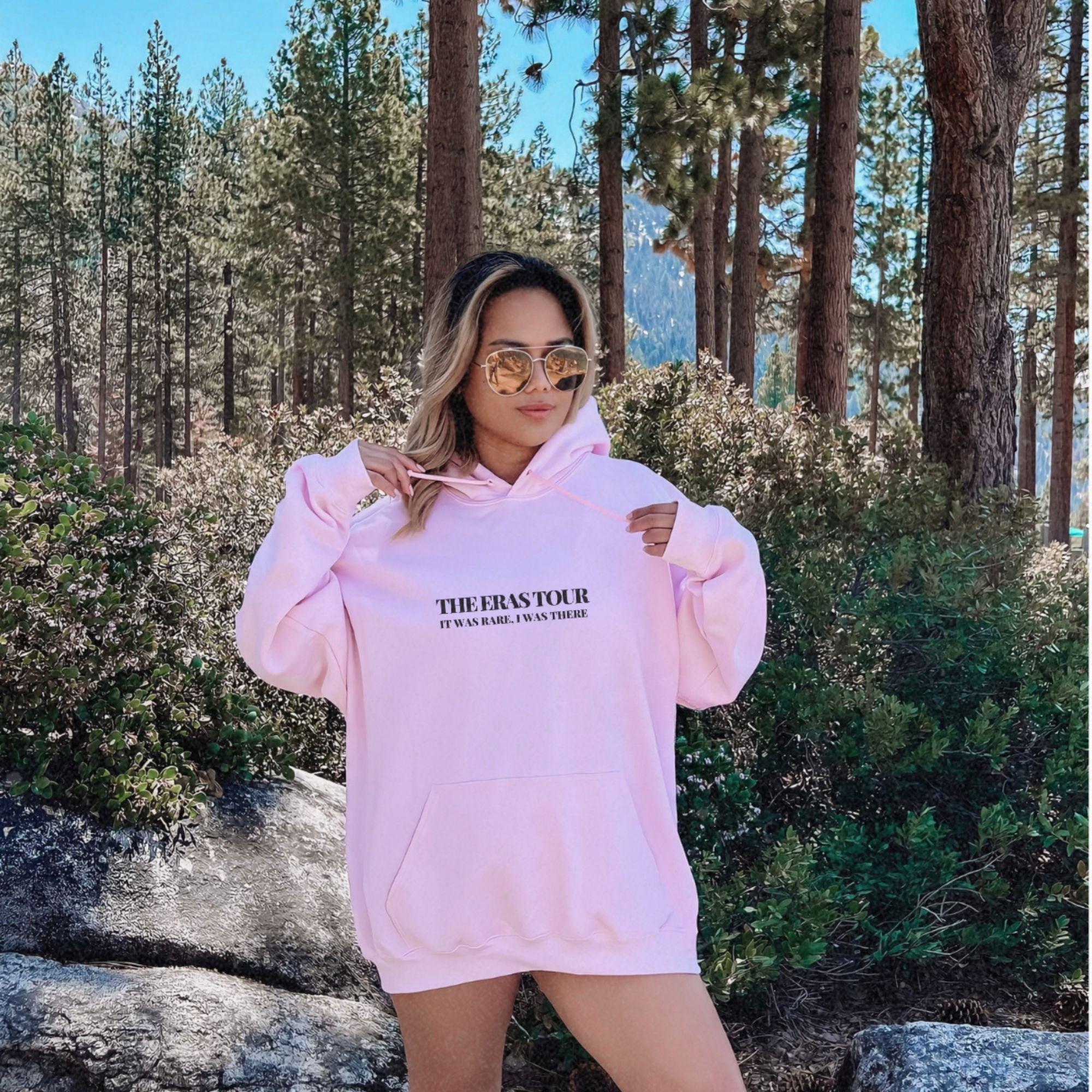 a woman in a pink hoodie posing for a picture