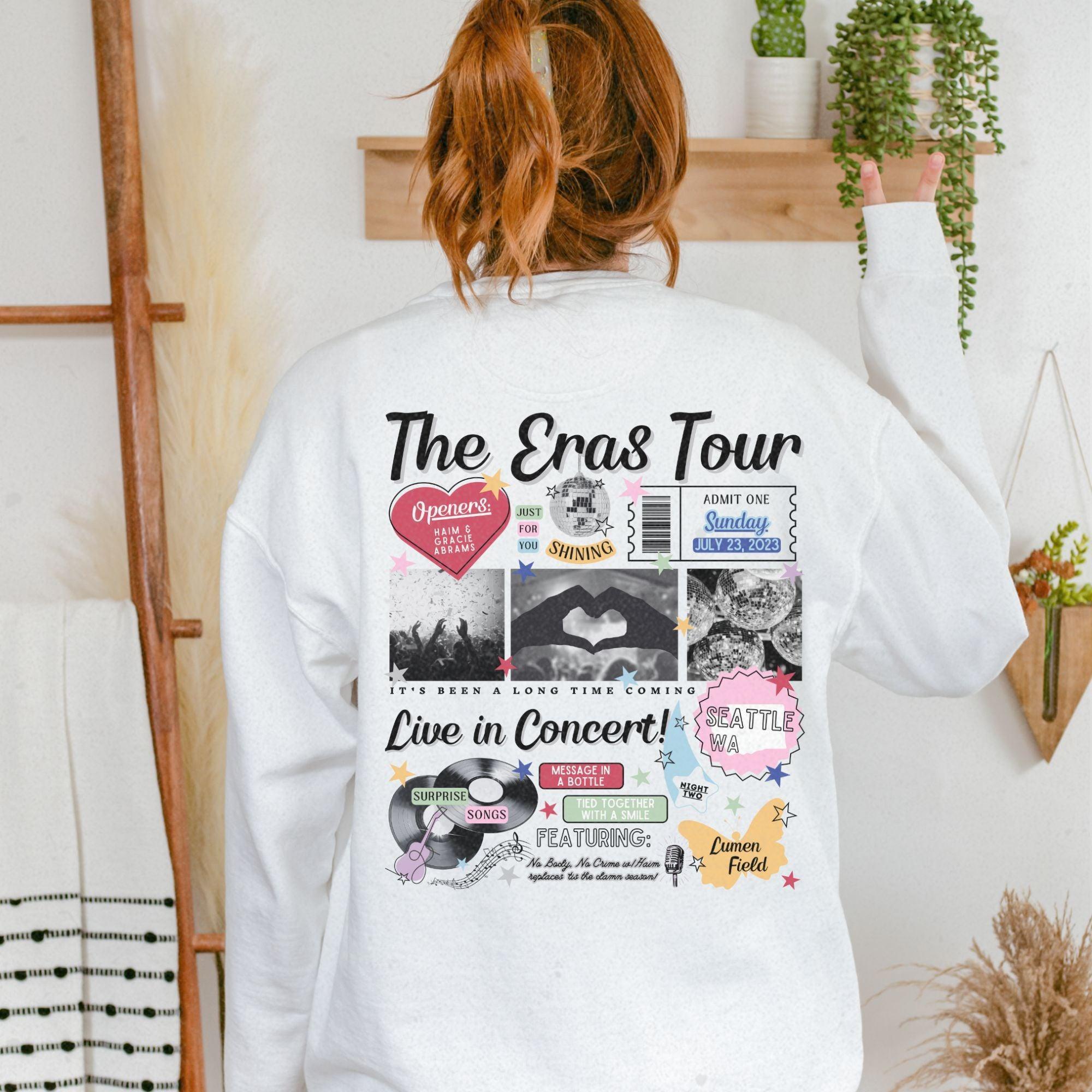 a woman wearing a white sweatshirt with the words the eras tour printed on it