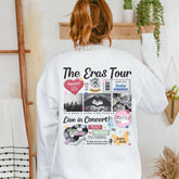 a woman wearing a white sweatshirt with the words the eras tour printed on it
