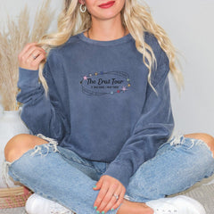 a woman sitting on the floor wearing a blue sweatshirt