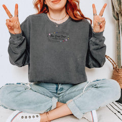 a woman sitting on the floor making the peace sign
