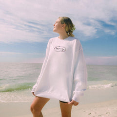 a woman standing on a beach next to the ocean