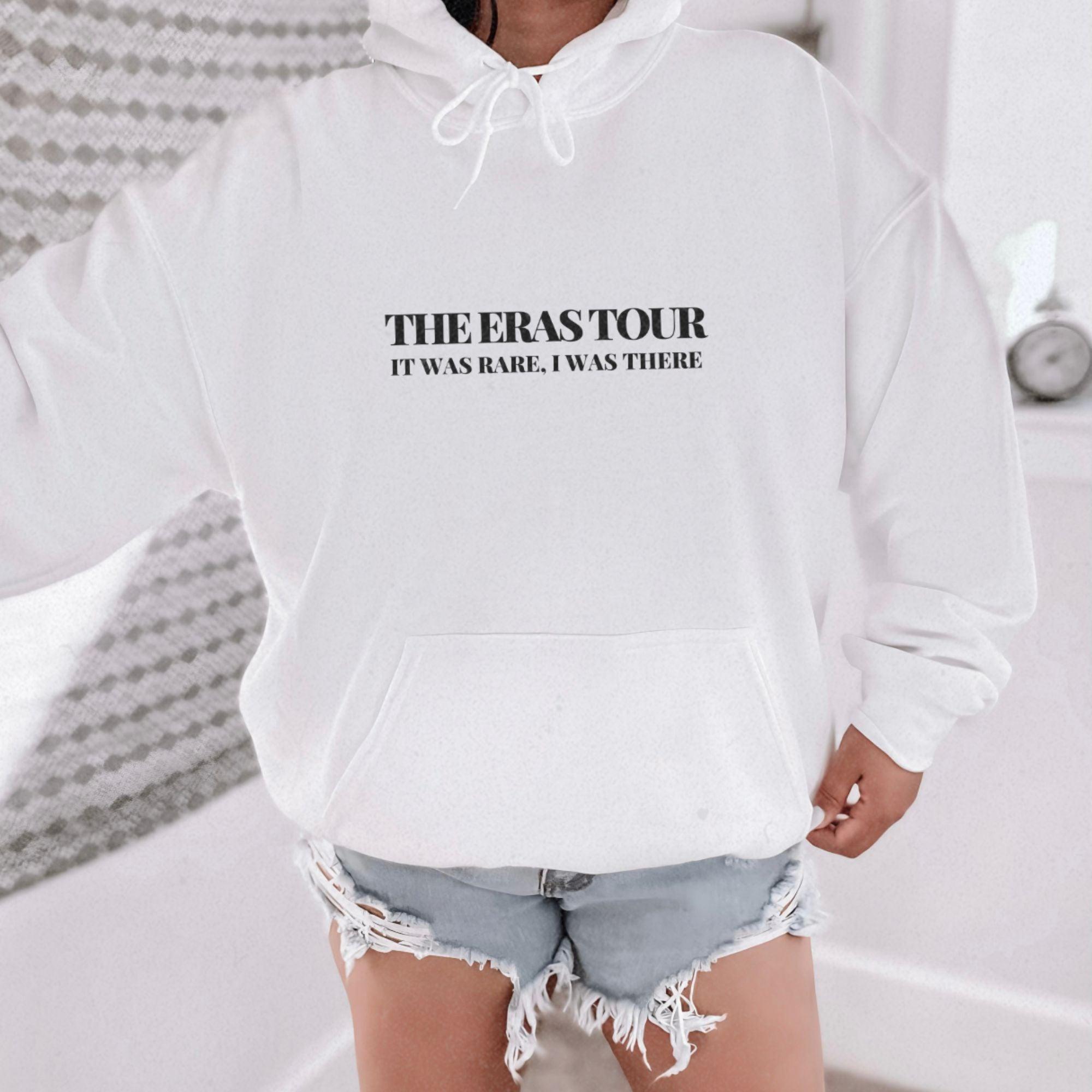 a woman wearing a white hoodie with the phrase the erase tour printed on it