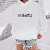 a woman wearing a white hoodie with the phrase the erase tour printed on it