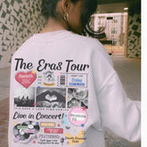 a woman wearing a white sweatshirt with the words the eras tour on it