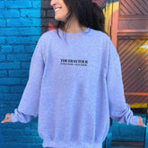 a woman standing in front of a blue brick wall