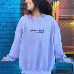a woman standing in front of a blue brick wall