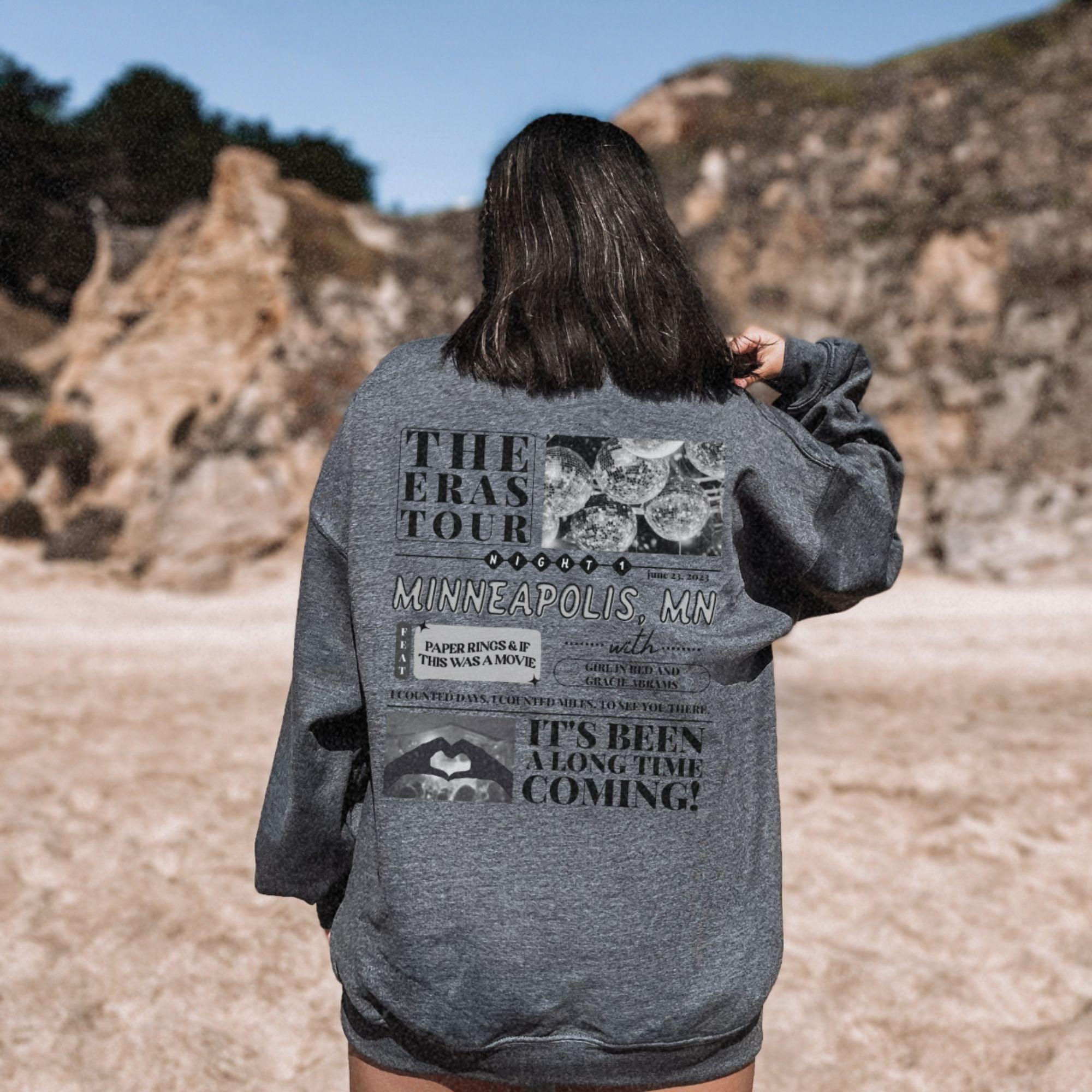 a woman standing in a field with her back to the camera