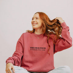 a woman sitting on the floor with her hair blowing in the wind