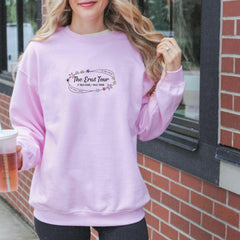 a woman in a pink sweatshirt holding a drink
