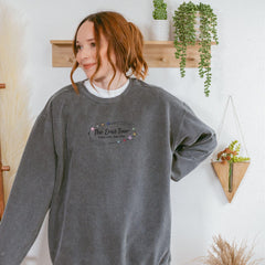 a woman standing in front of a wall with plants