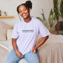 a woman sitting on top of a bed wearing a white shirt