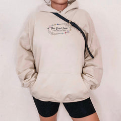 a woman wearing a white hoodie with the words the open tour on it