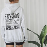 a woman wearing a white sweatshirt with the words atlanta on it