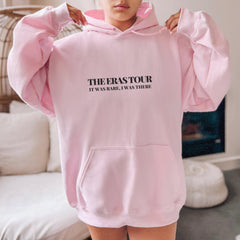 a woman in a pink hoodie holding up her pink sweatshirt