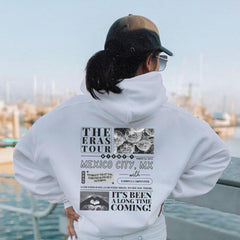 a person wearing a white hoodie looking at a body of water