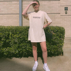 a woman standing in front of a hedge