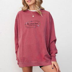 a woman wearing a red sweatshirt with the words the dove tour on it