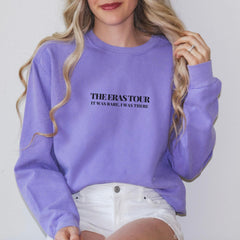 a woman wearing a purple sweatshirt and white shorts