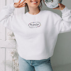 a woman wearing a white sweatshirt with the words the great tour on it