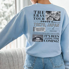 a woman in a blue sweatshirt is looking out a window