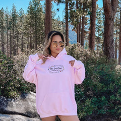 a woman in a pink hoodie posing for a picture