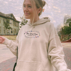 a woman in a white hoodie holding a cell phone