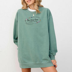 a woman wearing a green sweatshirt dress with the words the best tour on it