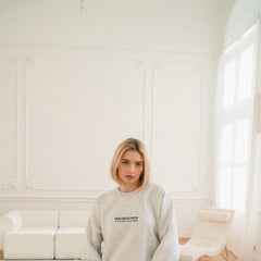 a woman standing in a room with a white couch
