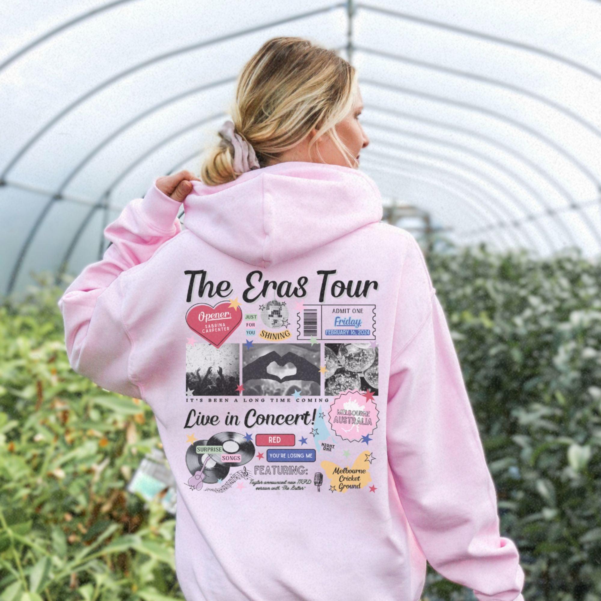 a woman in a pink hoodie is standing in a greenhouse