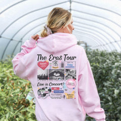a woman in a pink hoodie is standing in a greenhouse