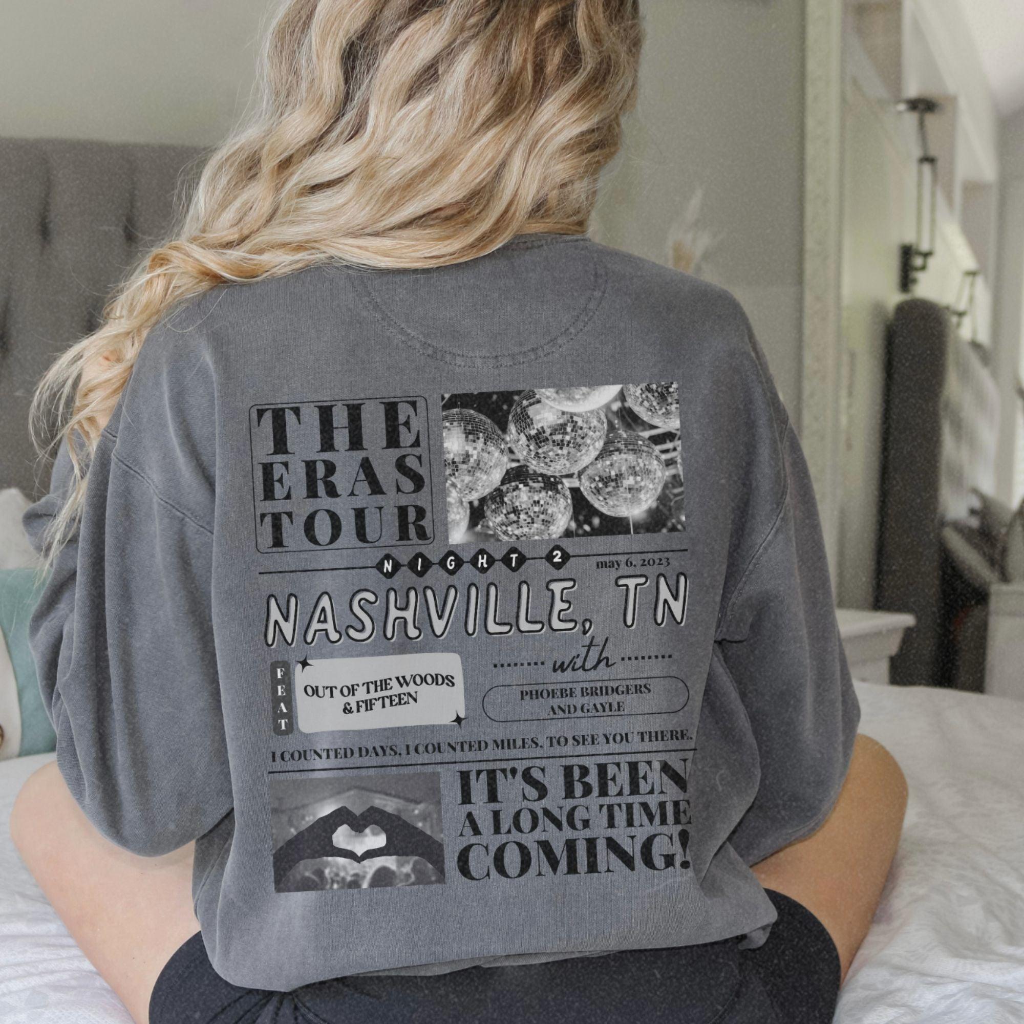 a woman sitting on top of a bed wearing a gray shirt