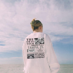 a woman standing on a beach looking at the ocean