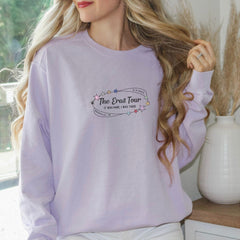 a woman wearing a purple sweatshirt and white pants