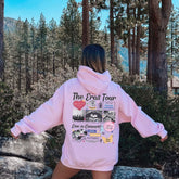 a woman in a pink hoodie standing on a rock
