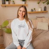 a woman sitting on a couch wearing a white sweatshirt