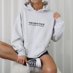 a woman in a grey hoodie is posing for a picture